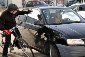 Radfahrer und Autofahrer kurz vor dem Zusammenprall